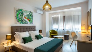 A modern hotel room with a large bed, a desk, a chair, and a painting on the wall. - Lagom Hotel (Bucharest)