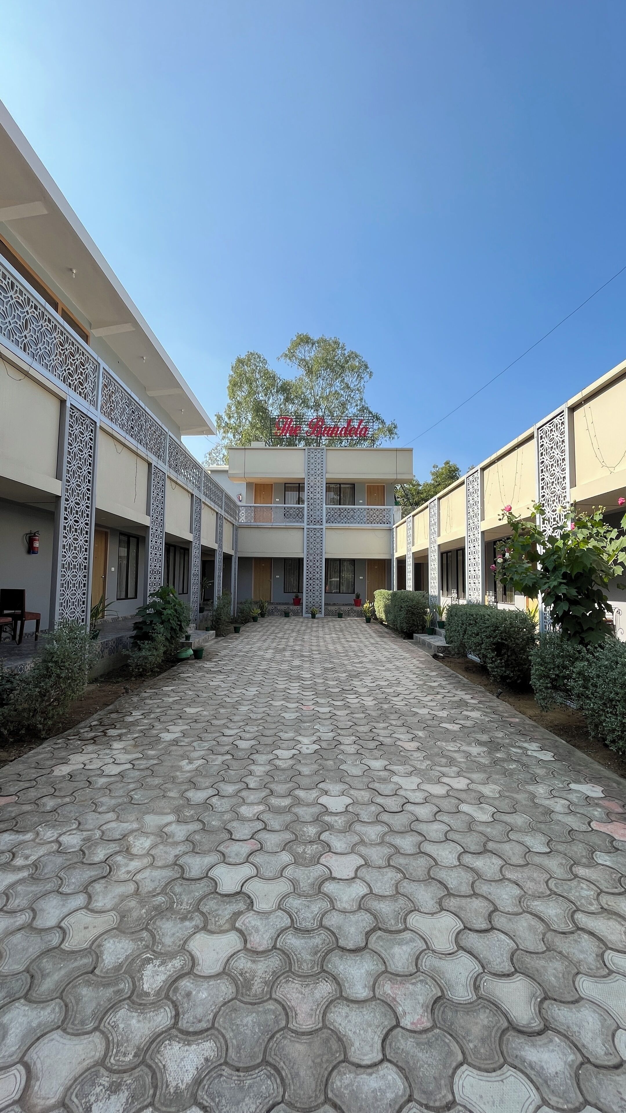A building with a central entrance, patterned columns, and a sign reading "The Gardenia."
