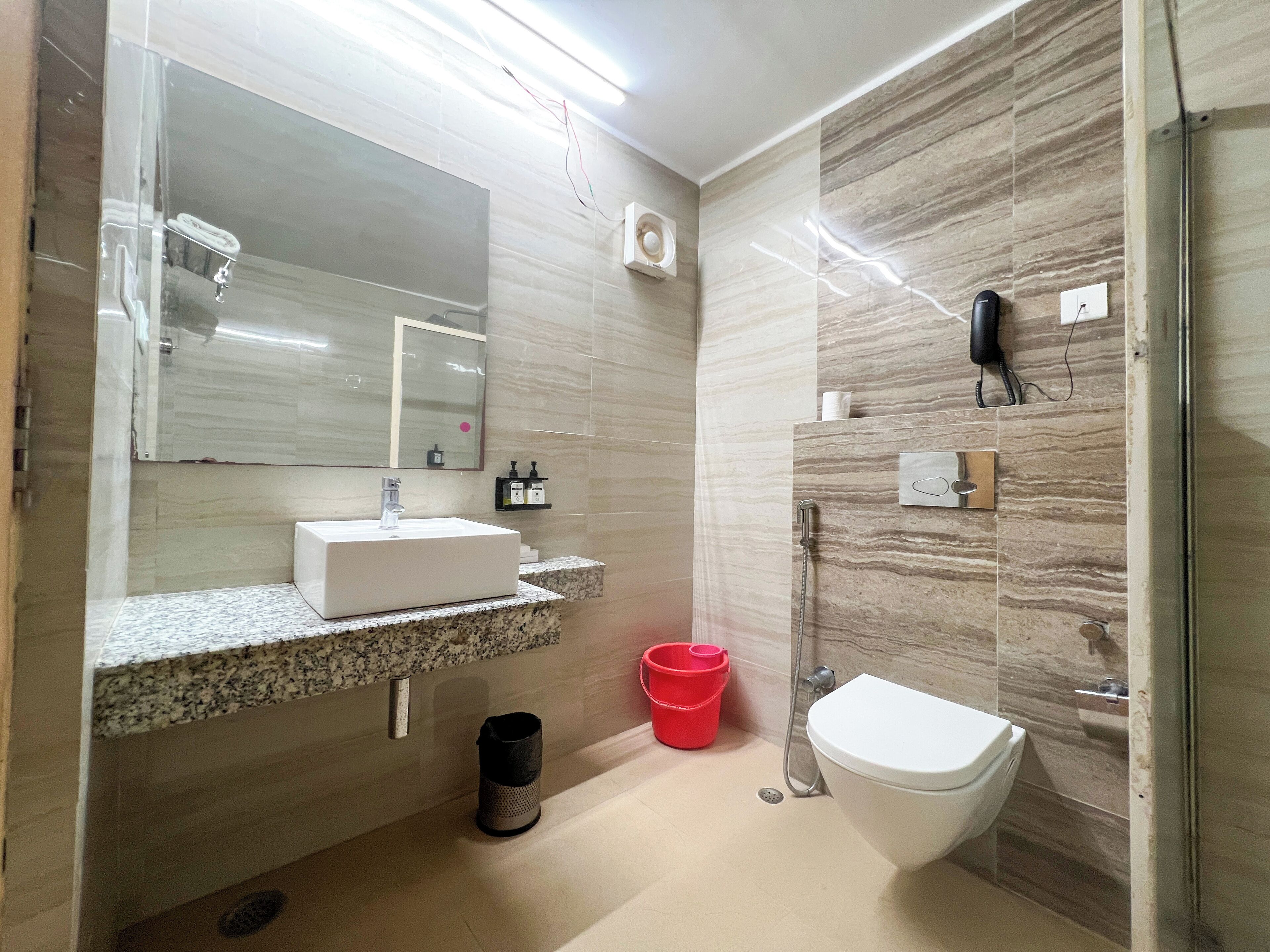 Une salle de bain moderne avec un lavabo rectangulaire, des toilettes et une douche.