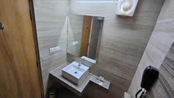 Een moderne badkamer met een houten deur, een witte wastafel, een spiegel en een douche.