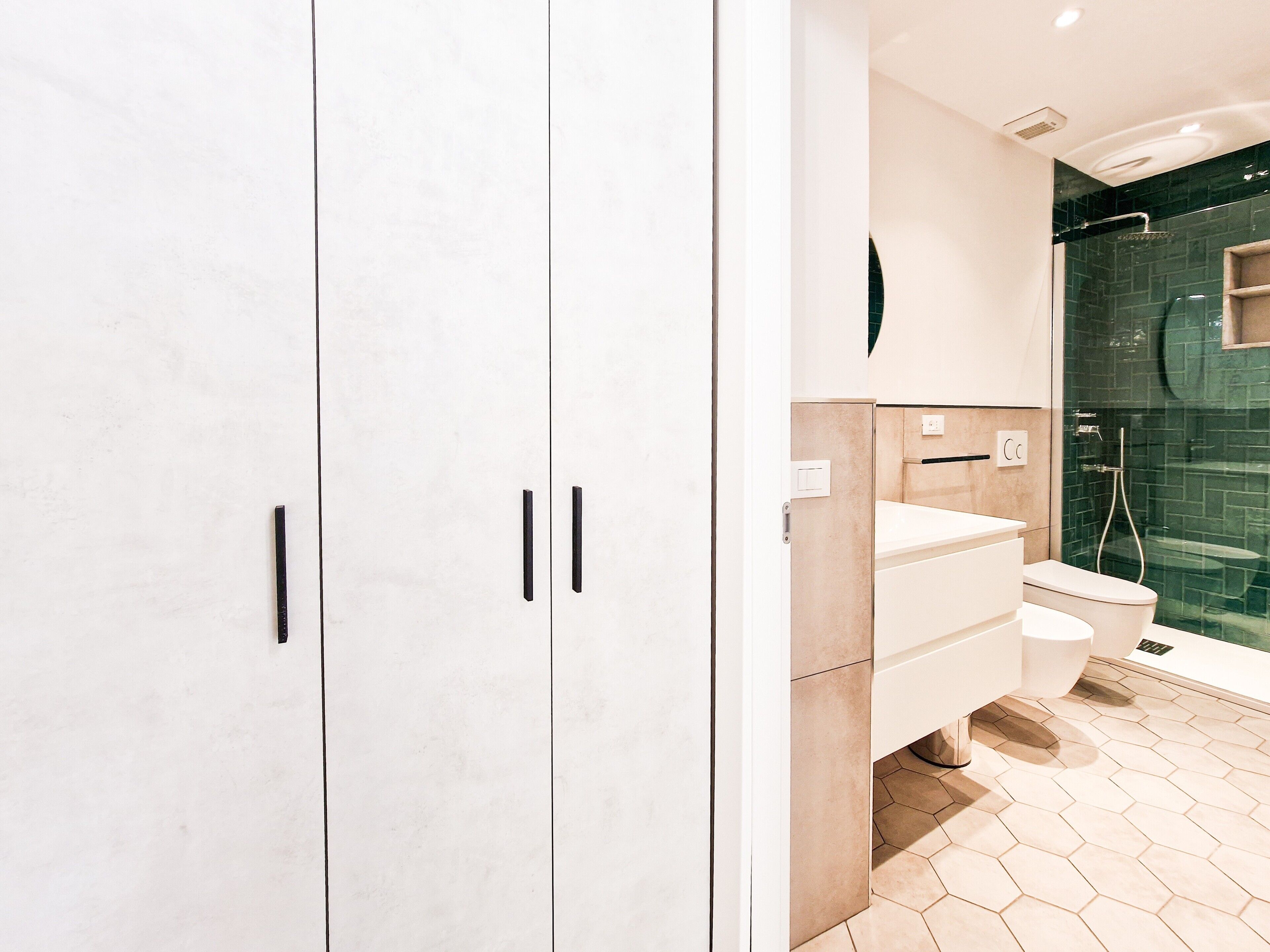 Un bagno moderno con un mobile lavabo bianco, un water e uno spazio doccia.
