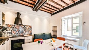 A kitchen with a white countertop, a patterned backsplash, and a built-in oven.
