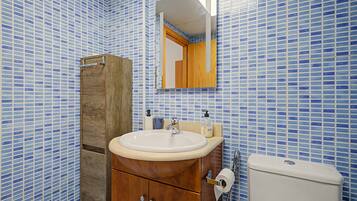 Un baño con un mueble de madera, un lavabo y un inodoro.