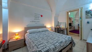 Un dormitorio con cama, lámparas de noche, un escritorio y un espejo.