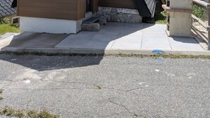 Une maison moderne avec un toit en pente, un petit porche et des fondations en pierre.