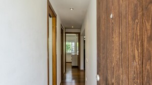 A hallway with a wooden door, a white wall, and a wooden floor. - Apartment "Olga" with Private Terrace and Wi-Fi (Platja d'Aro)