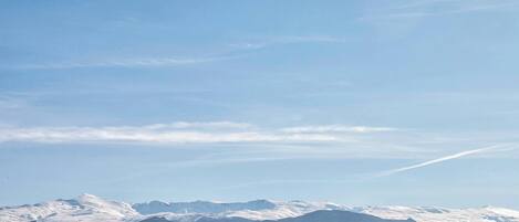 A mountain range with snow-covered peaks under a clear sky.