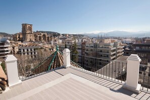 Una terrazza sul tetto con vista su una chiesa storica e sullo skyline della città.