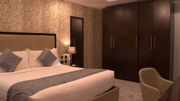 Quarto de hotel moderno com uma cama grande, mesa de cabeceira, escrivaninha e guarda-roupa.
