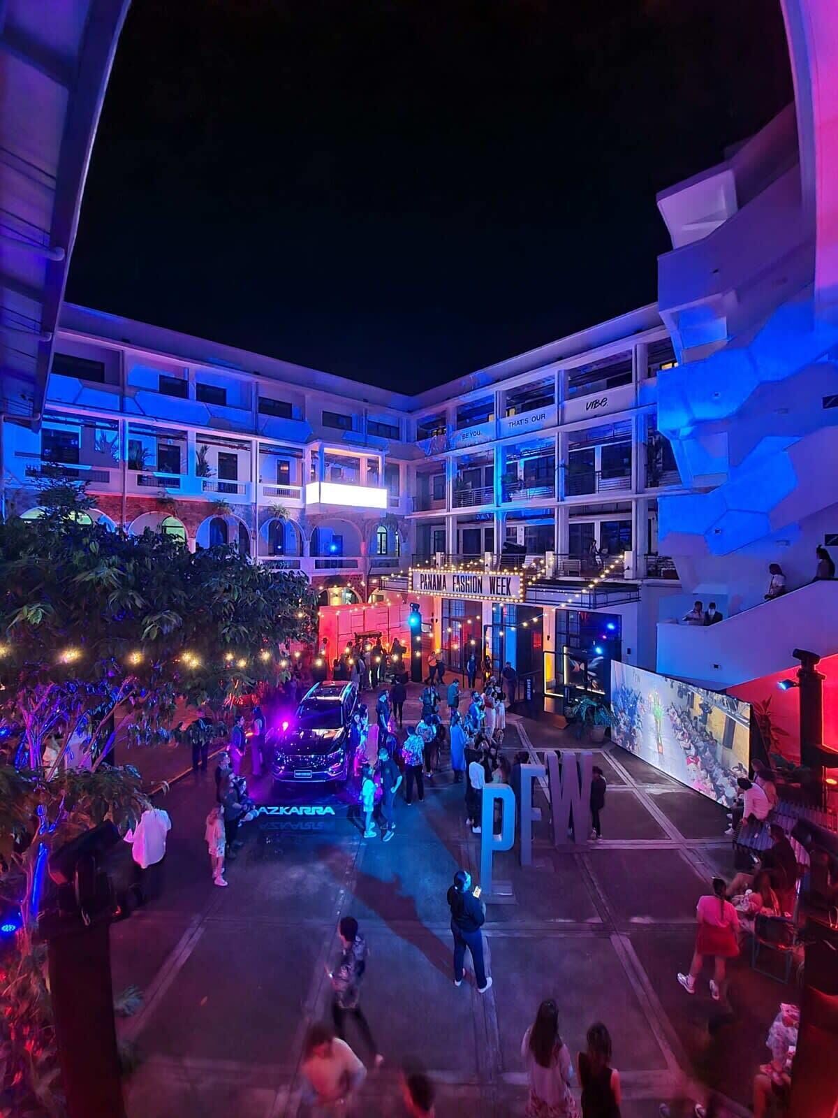 A multi-story building with balconies and a sign for "Panama Fashion Week."