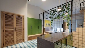 Une cuisine moderne avec un îlot central, des armoires vertes et un sol à motifs.