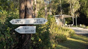 Un panneau indicateur avec des flèches pointant vers « Tiny House 3 », « Tiny House 2 » et « Tiny House 4 ».