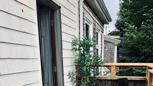 A patio with two turquoise chairs, a yellow patterned rug, and a wooden deck. - Pet-Friendly, Lovely Studio w/ Balcony (Halifax)
