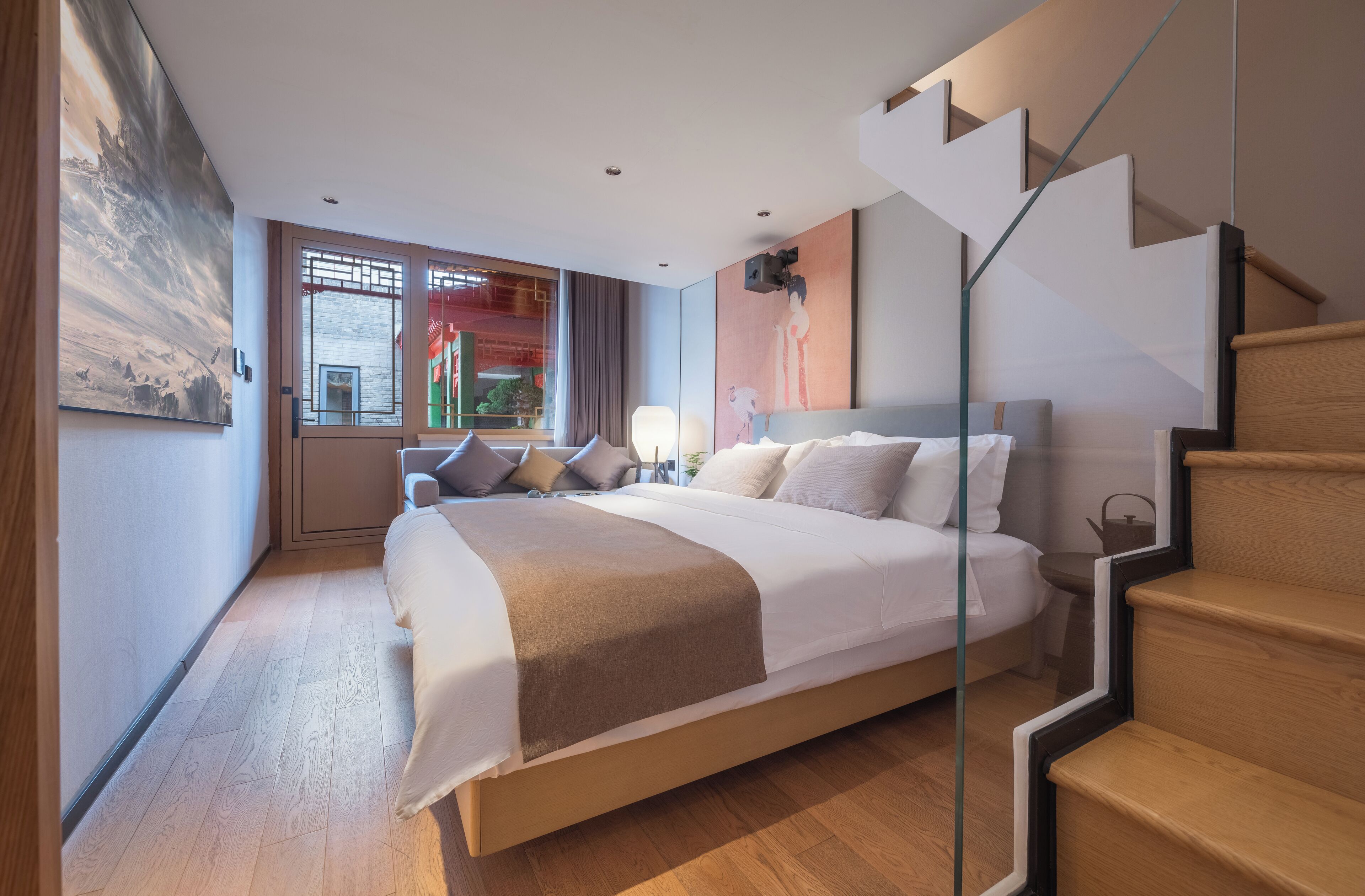 Una camera da letto moderna con un letto grande, una scala in vetro e vista sulla città.