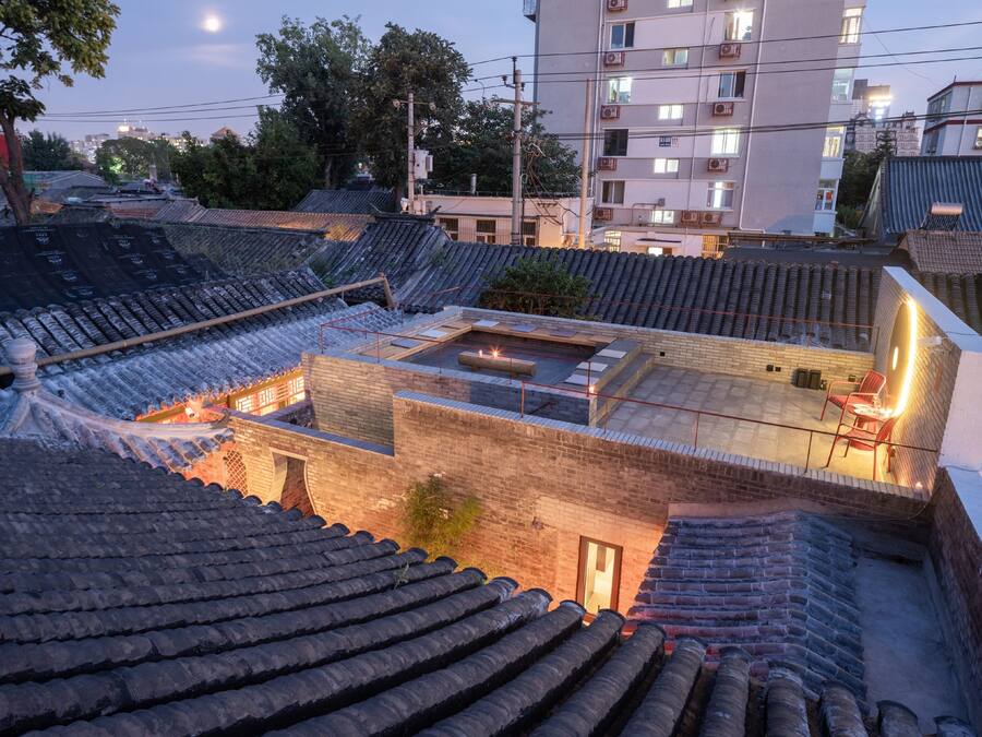 Un edificio japonés tradicional con un patio, techos de tejas y una estructura de ladrillo.