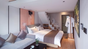 A modern loft bedroom with a loft bed, a sofa, a coffee table, and a staircase leading to an upper level. - XinXiangYaYuan Courtyard (Beijing)