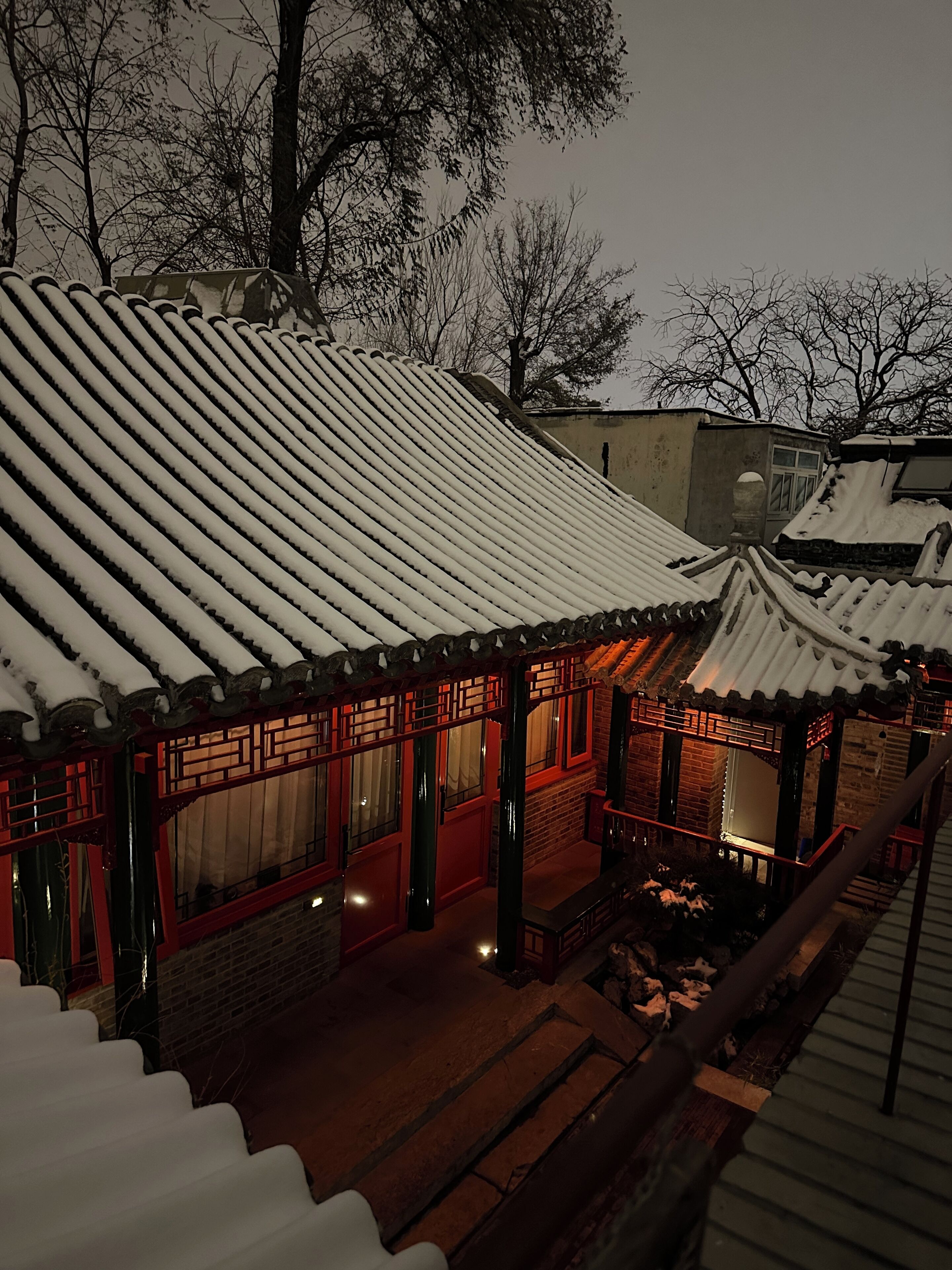 A traditional building with a snow-covered roof and red wooden structures.