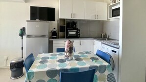 A compact kitchen with a refrigerator, microwave, coffee maker, and a small sink. - Stunning apartment with AC and terrace in Canet-en-Roussillon (Canet-en-Roussillon)