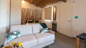 Una habitación de hotel moderna con un sofá blanco, un espejo grande y un techo de madera.