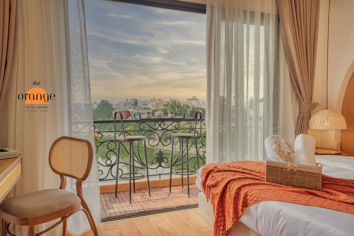 Een hotelkamer met balkon, een bed, een stoel en een tafel.