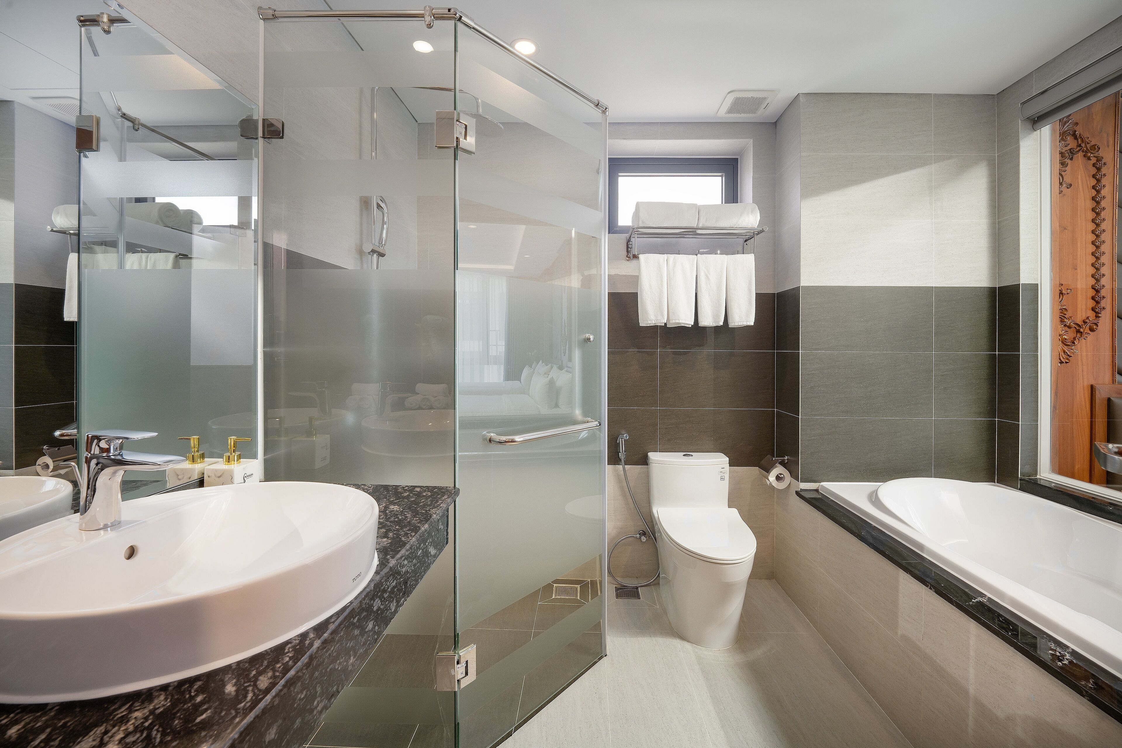 Un baño moderno con ducha envuelta en vidrio, un lavamanos grande, inodoro y bañera.