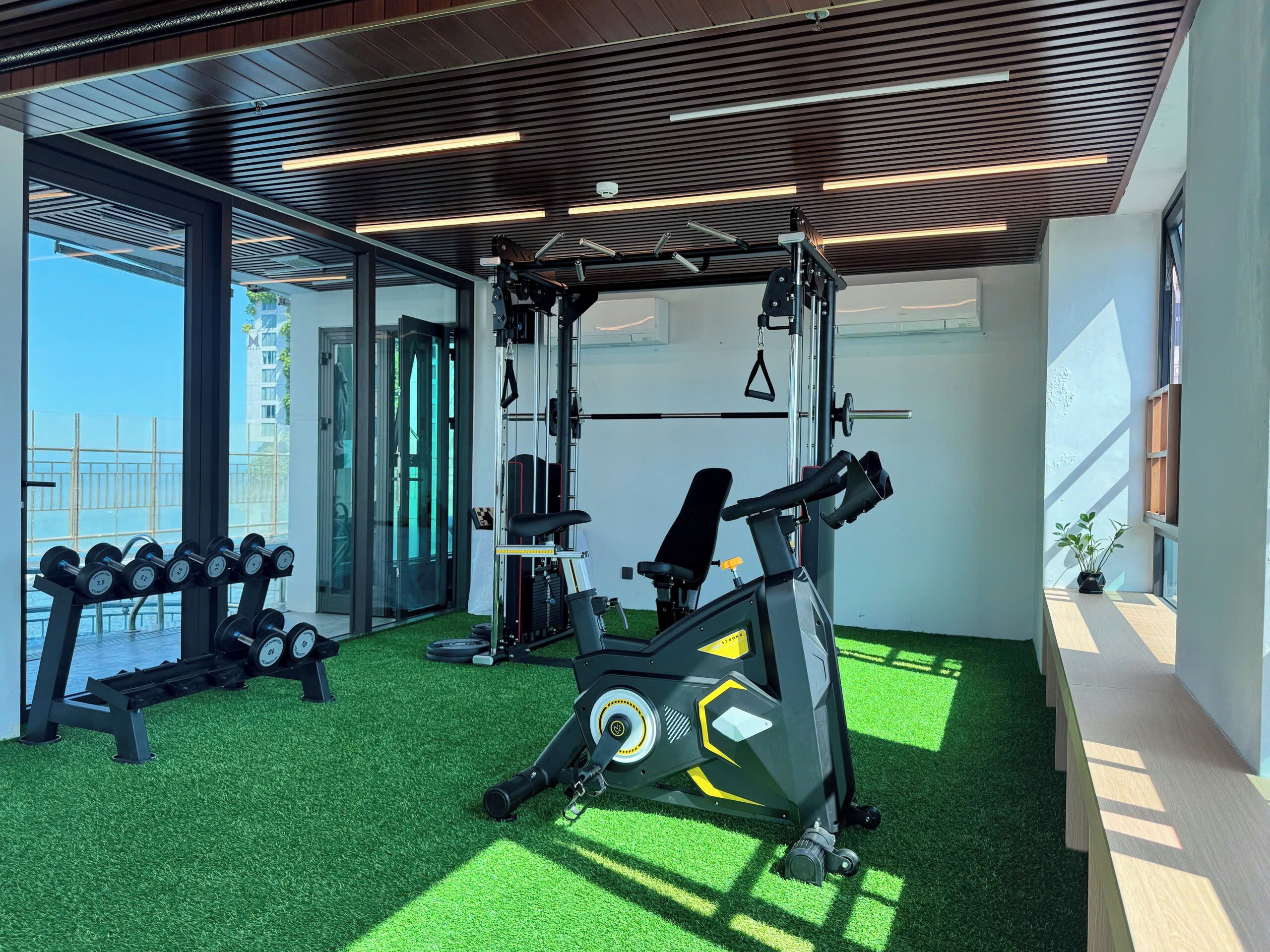 A gym with exercise equipment, a bench, and dumbbells.