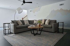 A modern living room with a sectional sofa, a round coffee table, and a floor lamp.