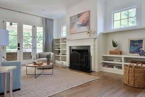Ein Wohnzimmer mit Kamin, einer Couch, einem Couchtisch und einem Bücherregal.