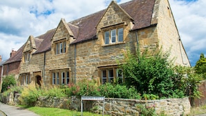 Un bâtiment en pierre à l’architecture traditionnelle, doté de nombreuses fenêtres et d’une enseigne indiquant son nom.