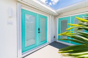 A building with teal-colored doors and windows, a white exterior, and a small sign indicating '2 Shark Pit'.