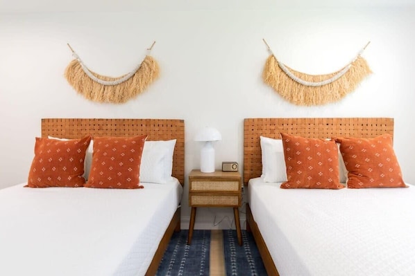 A double room with two beds, a nightstand, a lamp, and a wall-mounted decorative item. - THE JUNI ✺ Stunning Studio, Walk to Everything (Cocoa Beach)