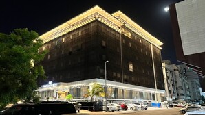 A modern building with a glass facade and a lit entrance. - Paradise Inn Jeddah (Jeddah)