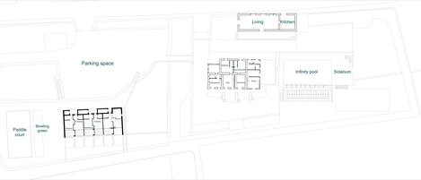 A floor plan with labeled areas such as a living room, kitchen, infinity pool, solarium, staff rooms, and a paddle court.
