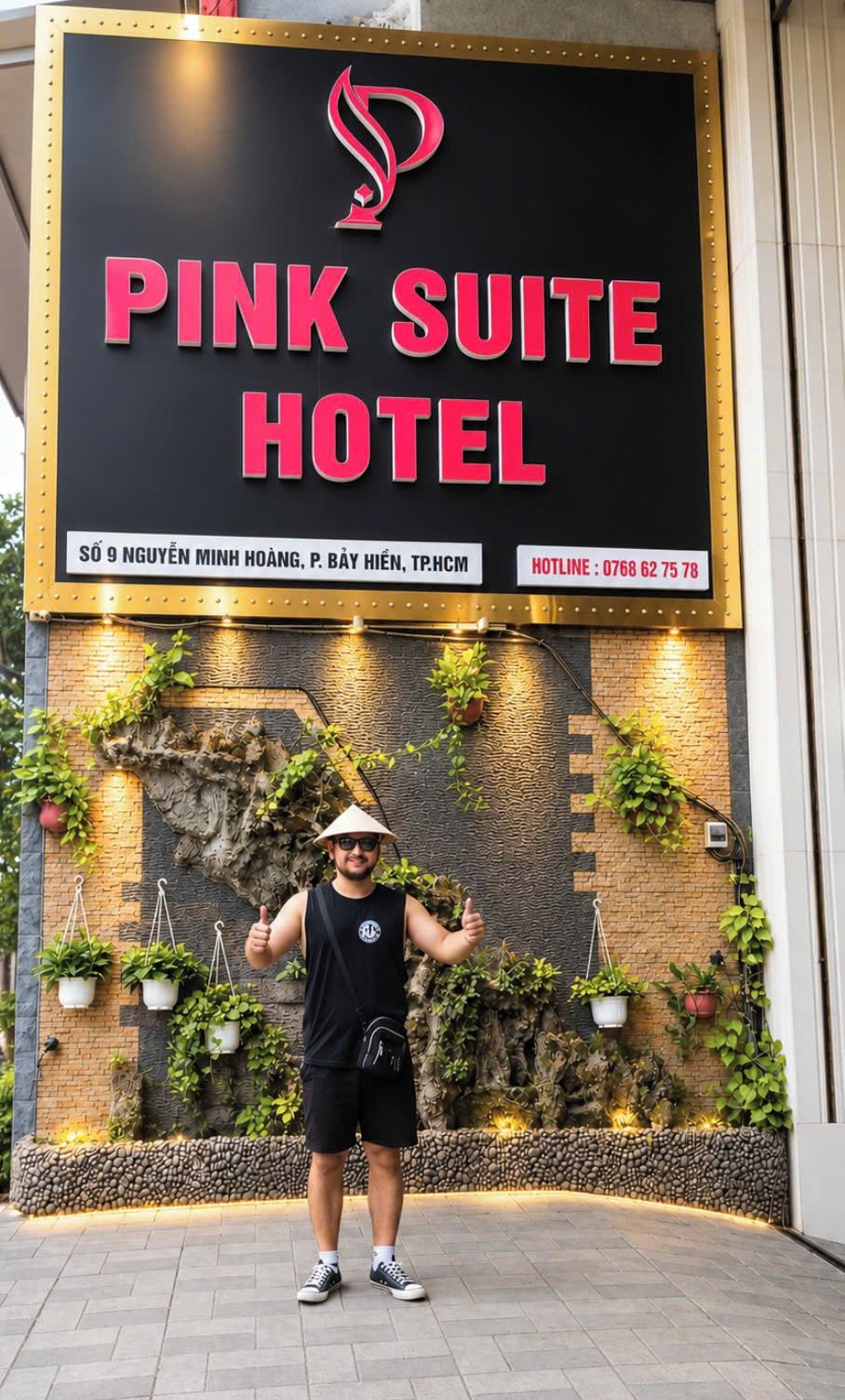 Schild des Pink Suite Hotels mit modernem Design, inklusive Logo, Adresse und Hotline-Nummer.