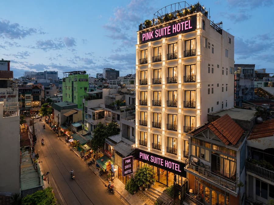Ein mehrstöckiges Hotel mit Balkonen und einem Schild, auf dem 'Pink Suite Hotel' steht.