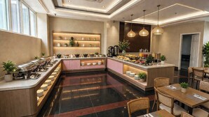 A modern hotel lobby with a buffet area, seating arrangements, and a reception desk. - Pink Suite Saigon Airport Hotel (Ho Chi Minh City)