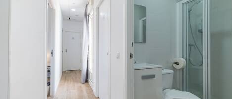 A modern bathroom with a toilet, shower, and a mirror.