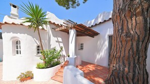 A white building with a tiled roof, a palm tree, and a large tree trunk. - Villa Aida Luxury Apartments & Spa (Forio)