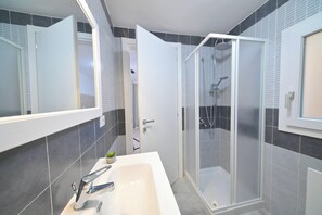 Superior studio | Badkamer | Een douche, een haardroger, een bidet, handdoeken