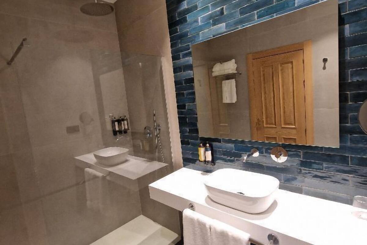 superior double room | bathroom | shower, rainfall showerhead, hair dryer, towels