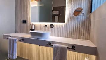 Een moderne badkamer met een grote spiegel, twee wasbakken en een handdoekrek.