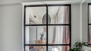 A room with a bed, a window with a view of a dining area, and a radiator. - Sanders Old Port - Lovely 1-bdr. Apt (Thessaloniki)