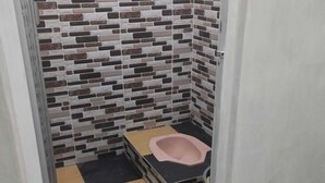 A small, narrow bathroom with a tiled wall and a checkered floor. - EXPRESS O 92070 Mando Homestay Syariah Near KANTOR LURAH Bukik Apik Puhun (Bukittinggi)