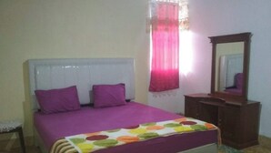 A bedroom with a bed, a dresser, a mirror, and a window with curtains. - EXPRESS O 92070 Mando Homestay Syariah Near KANTOR LURAH Bukik Apik Puhun (Bukittinggi)
