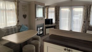 A cozy living area with a sofa, a small table, a TV, and a fireplace. - Hot tub Break Away Castle View (Lincoln)