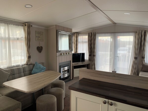 A cozy living area with a sofa, a small table, a TV, and a fireplace. - Hot tub Break Away Castle View (Lincoln)