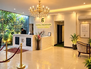 A hotel reception area with a reception desk, a chandelier, and a sign that reads 'HOTEL FOUNTAIN Luxury in comfort.' - Hotel Fountain (Dhaka)