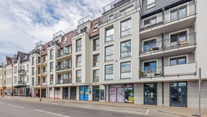 A multi-story building with balconies, storefronts, and a visible entrance. - Apartamenty Sun&Snow Bałtyk (Swinoujscie)