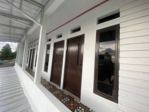 Guests can enjoy a covered porch with a tiled floor and doors leading to the building.
