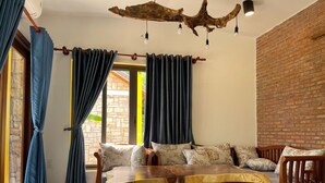 Ein gemütliches Wohnzimmer mit einer Couch, einem Holztisch und einer Ziegelwand.